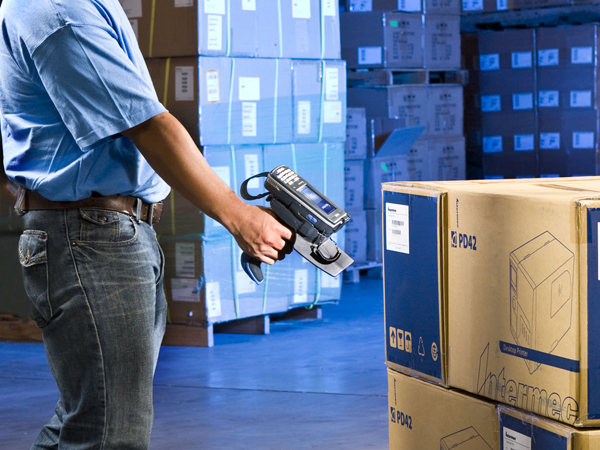Warehouse worker scanning boxes with a mobile device.